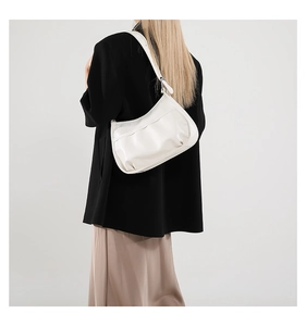 Side view of a white crescent Hobo bag with ruched details worn by a model in studio