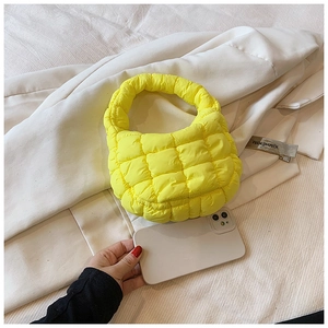 Detail view of mini yellow quilted cloud bag showing micro size and nylon texture
