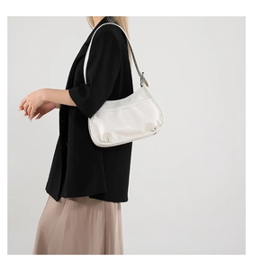 Detailed shot of white hobo bag with adjustable silver buckle on model's shoulder
