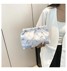 Detail of nylon pouch bag featuring landscape print and gathered pleated closure