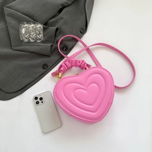Pink heart-shaped crossbody bag with quilted texture and ruched handle for women