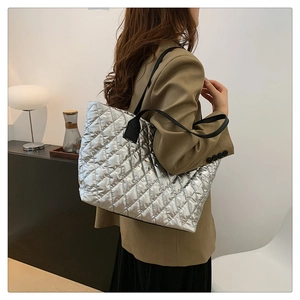 Vue latérale du sac fourre-tout argenté matelassé avec motif à losanges sur mannequin