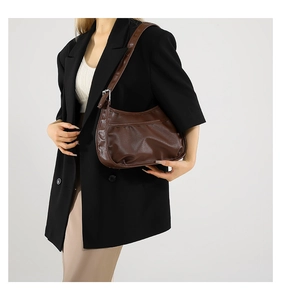 Brown matte leather hobo bag with pleated texture and adjustable strap on shoulder