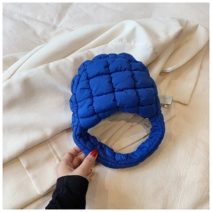 Detail of Klein blue quilted puffer bag fabric texture with zipper and soft check pattern