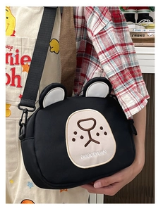 Detail of cute bear-shaped black canvas crossbody bag with adjustable nylon strap