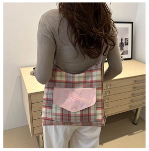 Detailansicht der rot-pink karierten Tragetasche mit rosa Schleifenstickerei auf der Tasche