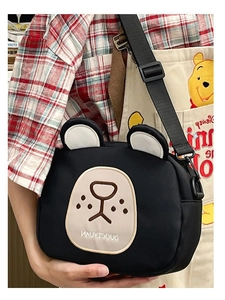 Detail view of black cartoon bear crossbody bag with adjustable strap and zip closure