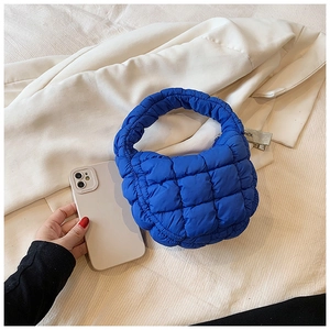 Detail view of the quilted electric blue mini cloud handbag with soft puffed fabric texture