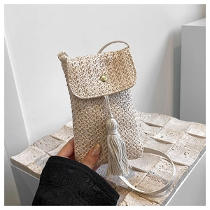Détail du sac de téléphone en paille beige avec de longues franges et fermoir doré