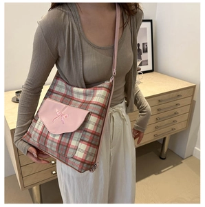 Detailaufnahme der roten Karo-Tasche mit pinker Ledertasche und Schleifenstickerei