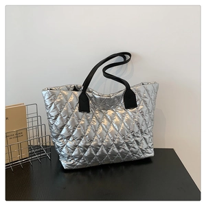 Détail du sac cabas matelassé argenté avec texture métallisée et bandoulière noire