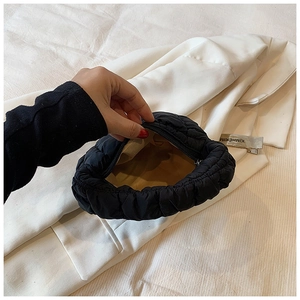 Close-up of black puffy quilted bag with smooth zipper closure and spacious interior lining