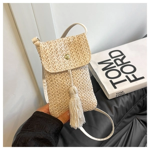 Détail du petit sac bandoulière d'été en paille tressée avec pompon et boucle magnétique
