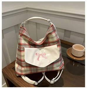 Detailansicht der karierten Tragetasche mit rosa Schleifenstickerei und weißer Ledertasche