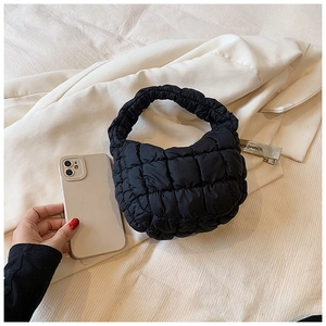 Detail of black quilted cloud bag showing soft bubble texture and mini compact size