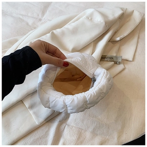 Detail view of the white cloud bag featuring soft quilted fabric and smooth zipper closure