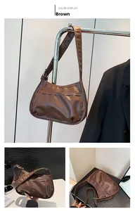 Close-up of brown vintage crescent shoulder bag with pleated matte leather and front pocket