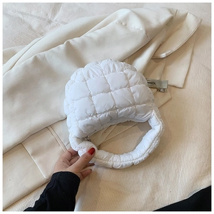 Detailed macro shot of white quilted puffy cloud bag with textured bubble fabric and handle