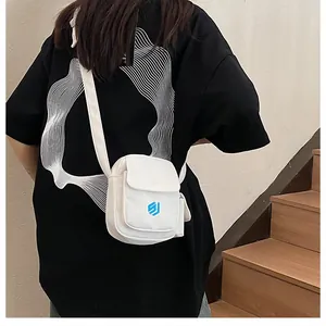 Weiße lässige Umhängetasche für Handys am Model mit langem Gurt und schlichtem Design