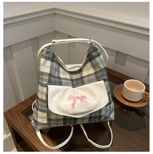 Detail der grau-grünen Karo-Tasche mit rosa Schleifen-Stickerei auf weißer Tasche