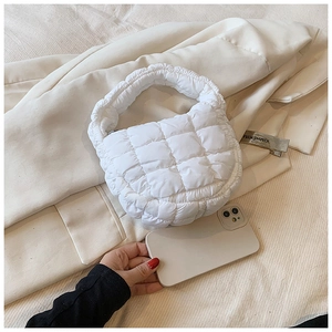 Mini white quilted cloud bag detail showing soft puffy texture and sleek handles