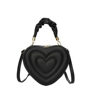 Fashionable heart-shaped black handbag with quilted layers and a ruffled handle