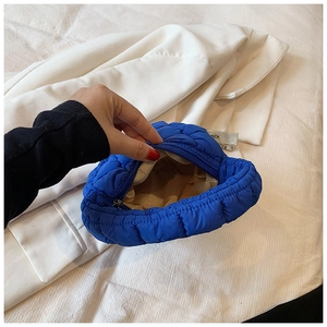 Detail view of the vibrant blue quilted bubble bag showing interior lining and silver zipper