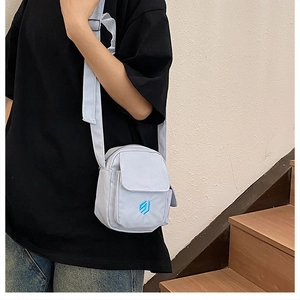 Seitenansicht einer hellblauen Nylon-Umhängetasche an einem Model mit Gurt