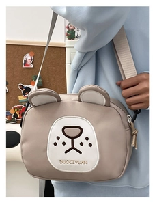 Detail of cute bear crossbody bag featuring fine embroidery and adjustable wide strap