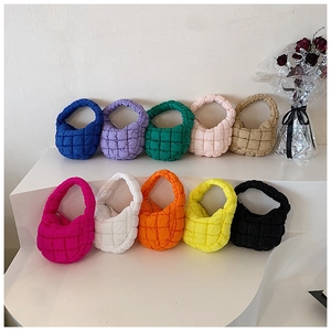 Close-up of quilted bubble mini bags in ten vibrant colors on a white display stand