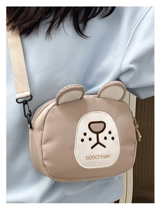 Detail of cute bear crossbody bag with 3D ears, embroidered face and adjustable strap