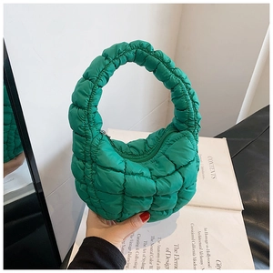 Macro shot of vibrant green quilted cloud bag showing puff texture and side mirror view