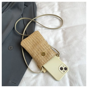 Détail de la pochette téléphone tressée avec fermoir magnétique doré et bandoulière