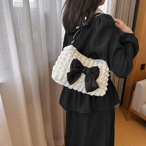 Minimalistische weiße Schultertasche mit Blasenstruktur und schwarzer Schleife