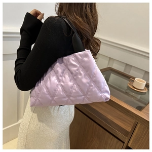 Détail d'un sac cabas violet matelassé avec texture brodée sur le bras du mannequin