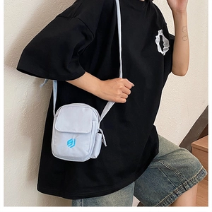 Detail der hellblauen Nylon-Umhängetasche mit Vordertasche und besticktem Logo