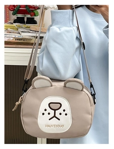 Detail view of cute bear crossbody bag featuring adjustable black strap and soft beige canvas