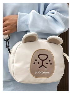 Detailed view of white cartoon bear canvas crossbody bag with adjustable black strap