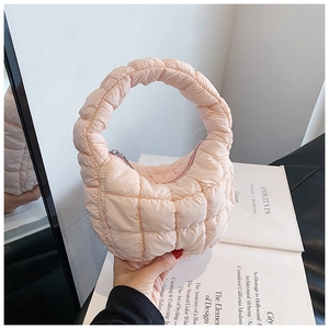 Detail of light pink crescent cloud bag featuring soft quilted nylon and a metal zipper