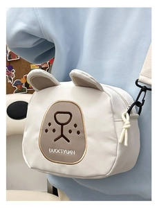Detailed close-up of a cute white bear canvas crossbody bag with brown embroidery
