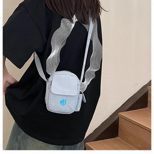 Detailansicht der blau-grauen Handy-Umhängetasche aus Nylon mit Logo und Klappenverschluss