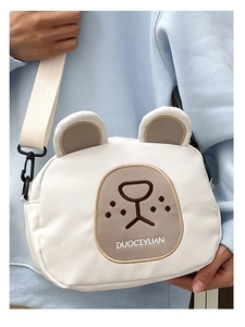 Detail of cute white bear cartoon canvas crossbody bag with adjustable wide strap and logo