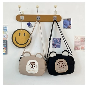 Detail showing cute bear-shaped canvas crossbody bags with 3D ears and embroidery
