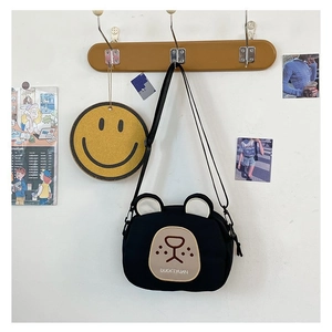 Detail of cute black bear crossbody canvas bag with adjustable strap and bear ear design