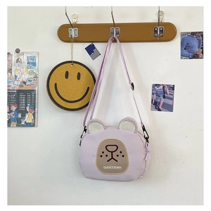Detail of light purple canvas crossbody bag featuring a cute bear face with embroidery