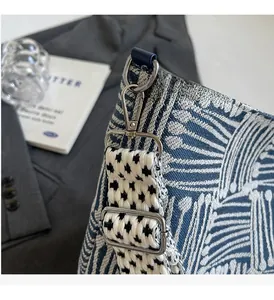 Detail of blue and white geometric jacquard canvas bag with silver metal lobster clasp