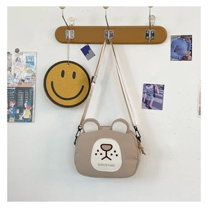 Close-up of khaki cartoon bear canvas crossbody bag with adjustable nylon shoulder strap