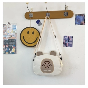 Detail of cute bear crossbody bag on wooden hook with stylish minimalist wall decor