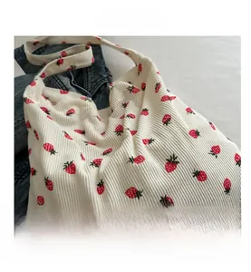 Détail d'un sac cabas en velours côtelé blanc avec motifs de fraises et bandoulière souple
