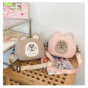 Detail of cute bear-shaped canvas crossbody bags in pink and brown with adjustable straps